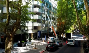 Elevador de muebles mecánico de Empresa Dante realizando un servicio de mudanza técnica en un edificio de Montevideo, alcanzando 30 metros de altura con plataforma de seguridad.
