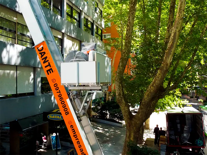 Operación de izaje técnico con elevador mecánico de Empresa Dante para subir muebles por fachada en edificios de Montevideo.